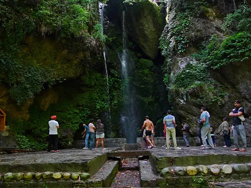 Couple enjoying peaceful view at Jibhi Waterfall forest bench
